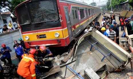 Evakuasi Bangkai Bus Metromini. Petugas melakukan evakuasi bangkai Bus Metromini pascatabrakan dengan KRL di Kawasan Stasiun Angke, Jakarta Barat, Ahad (6/12). 