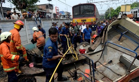 Evakuasi Bangkai Bus Metromini. Petugas melakukan evakuasi bangkai Bus Metromini pascatabrakan dengan KRL di Kawasan Stasiun Angke, Jakarta Barat, Ahad (6/12).