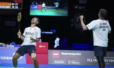 Fajar Alfian (kiri) dan Muhammad Rian Ardianto bereaksi saat pertandingan Final Ganda Putra melawan petenis Indonesia Marcus Fernaldi Gideon dan Kevin Sanjaya Sukamuljo dari Denmark Badminton Open, di Jyske Bank Arena di Odense, Denmark, Ahad (23/10/2022). 