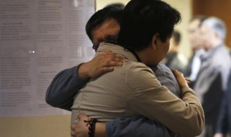 Family members of a passenger onboard the missing Malaysian Airlines flight MH370 hug each other as they wait for news about the missing plane at a hotel in Beijing March 20, 2014.