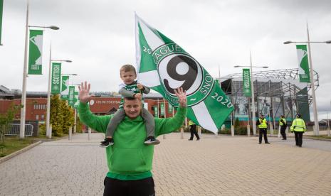 Fan Celtic merayakan gelar juara Liga Sepak Bola Skotlandia (SPFL) musim 2019/2020 di Celtic Park, Glasgow, Senin (18/5). SPFL mengumumkan kompetisi disetip dan Celtic menjadi juara karena pandemi Covid-19. 