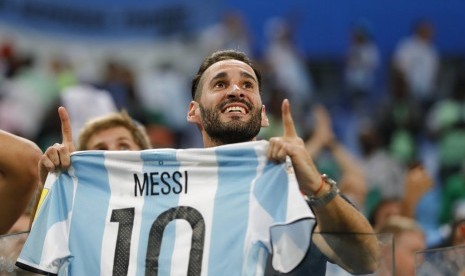 Fan memegang kostum Lionel Messi di Stadion Saint Petersburg, Rusia.