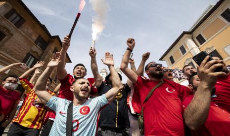 Fan Timnas Turki menyalakan flare sebagai rasa gembira menyambut laga pembuka Grup A Euro 2020 antara Turki lawan Italia di Roma, Italia, Jumat (11/6).