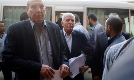 Fatah official and delegation leader Azzam Ahmed (C) and Maher al-Taher (L) from the leftist Popular Front for the Liberation of Palestine arrive at a hotel after negotiations in Cairo August 13, 2014. The threat of renewed war in Gaza loomed on Wednesday 