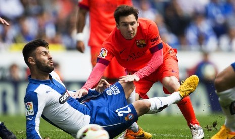  FC Barcelona's Argentinian striker Lionel Messi (R) in action against Espanyol's defender Ruben Duarte (L) during the Spanish Primera Division soccer match between RCD Espanyol and FC Barcelona in Barcelona, northeastern Spain, 25 April 2015. 