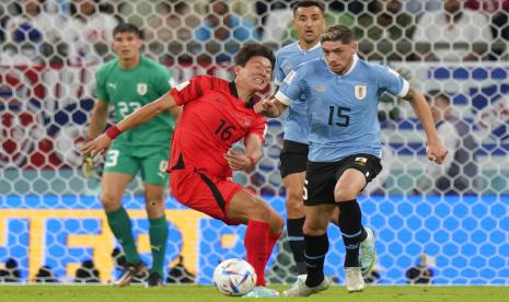  Federico Valverde dari Uruguay (kanan) dan Hwang Ui-jo dari Korea Selatan memperebutkan bola selama pertandingan sepak bola grup H Piala Dunia antara Uruguay dan Korea Selatan, di Stadion Education City di Al Rayyan, Qatar, Kamis, 24 November 2022. 