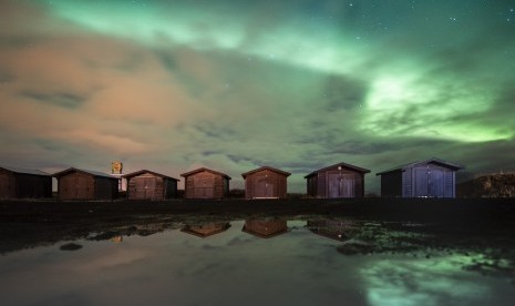 Fenomena alam aurora borealis atau northern lights tampak di langit dekat Reykjanesbaer di Islandia, (14/10).