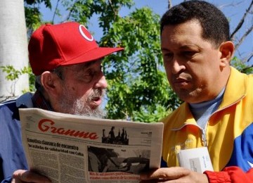 Fidel Castro (kiri) dan Presiden Venezuela, Hugo Chavez, berbincang membahas berita koran lokal Granma di tempat tersembunyi di Havana, Kuba, Selasa (28/6).