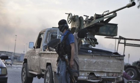 Fighters of the Islamic State of Iraq and the Levant (ISIL) stand guard at a checkpoint in the northern Iraq city of Mosul, June 11, 2014.