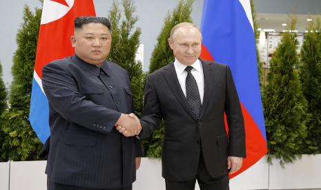  FILE - Presiden Rusia Vladimir Putin (kanan) dan pemimpin Korea Utara Kim Jong Un berjabat tangan selama pertemuan mereka di Vladivostok, Rusia, 25 April 2019. Korea Utara (Korut) membantah tudingan yang menyebutnya memasok persenjataan ke Rusia. Tuduhan terhadap Korut itu dilayangkan oleh Amerika Serikat (AS).