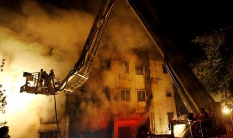 Firefighters battle a fire at a garment factory in the Savar neighborhood in Dhaka, Bangladesh, late Saturday, Nov. 24, 2012. At least 112 people were killed in a fire that raced through the multi-story garment factory just outside of Bangladesh's capital,