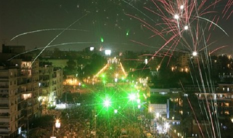 Fireworks burst over opponents of Egypt's President Mohammed Mursi during a rally outside the Presidential palace, in Cairo, Egypt, Sunday, July 7, 2013.