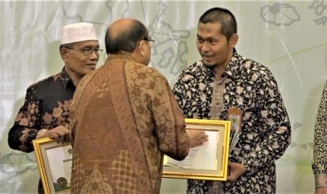 Firman ZA dari Laznas BMH menerima sertifikat dan tropi penghargaan Baznas Award 2019.