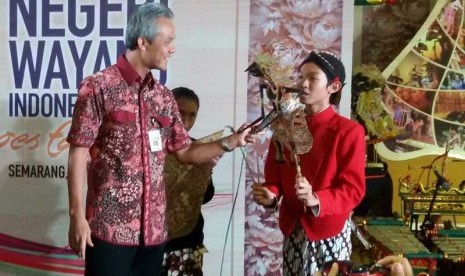 Foe Jose Amadeus Khrisna (memegang wayang) bersama dengan Gubernur Jawa Tengah, Ganjar Pranowo