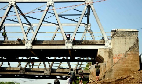 Fokus Pengerjaan Jembatan Darurat. Petugas bersama aparat TNI bersama mengrjakan pembangunan jembatan darurat pasca amblesnya Jembatan Comal, Pemalang, Jawa Tengah, Senin (21/7). (Republika/ Wihdan)