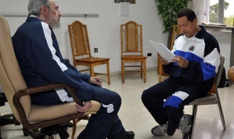 Former Cuban leader Fidel Castro (left) looks on as Venezuela's President Hugo Chavez reads a document in Havana in this July 3, 2011 file handout photo. 