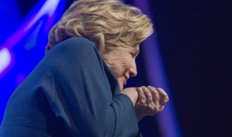 Former US Secretary of State Hillary Rodham Clinton ducks as an object is thrown on stage at the Mandalay Bay Convention Center, Thursday, April 10, 2014, in Las Vegas. 