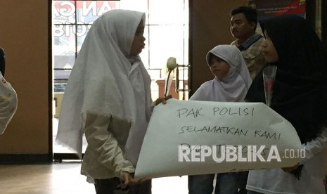 Forum Anak Cakung bersama perwakilan KPAI, berikan bunga kepada anggota polisi di Polres Metro Jakarta Timur, kepada Wakapolres Metro Jakarta Timur mereka meminta agar polisi melindungi anak-anak dari doktrin terorisme, Sabtu (19/5). 