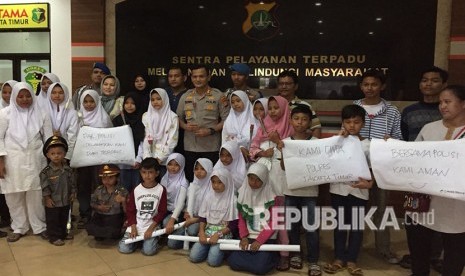 Forum Anak Cakung bersama perwakilan KPAI, berikan bunga kepada anggota polisi di Polres Metro Jakarta Timur, kepada Wakapolres Metro Jakarta Timur mereka meminta agar polisi melindungi anak-anak dari doktrin terorisme, Sabtu (19/5). 