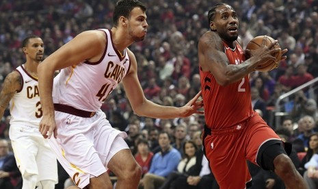 Forward anyar Toronto Raptors, Kawhi Leonard (2) mencoba melewati center Cleveland Cavaliers Ante Zizic (41) dalam pertandingan NBA musim 2018/2019, Kamis (17/10) di Toronto