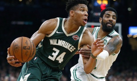 Forward Milwaukee Bucks Giannis Antetokounmpo (34) membawa bola melewati guard Boston Celtics Kyrie Irving pada gim ketiga babak kedua play-off NBA, Sabtu (4/5) WIB.