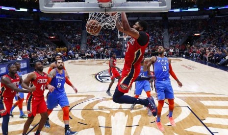 Forward New Orleans Pelicans, Anthony Davis, melakukan dunk saat menghadapi Oklahoma City Thunder dalam pertandingan NBA, Kamis (12/12).