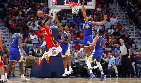 Forward New Orleans Pelicans Brandon Ingram berusaha menembak dijaga guard Golden State Warriors Jacob Evans (tengah) dalam pertandingan NBA di New Orleans, Selasa (29/10) WIB. 