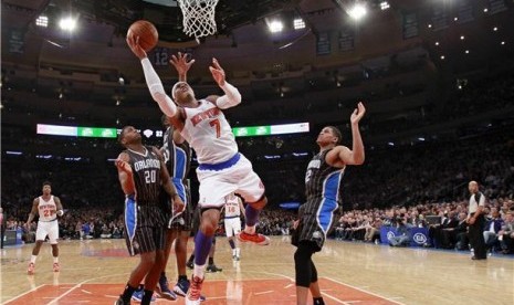 Forward New York Knicks, Carmelo Anthony (tengah), melakukan drives di bawah kepungan pemain Orlando Magic, DeQuan Jones (kiri) dan Tobias Harris, dalam laga NBA di Madison Square Garden, New York, Rabu (20/3) 