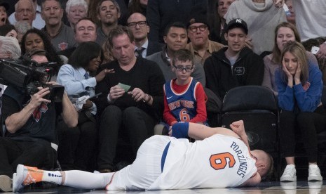 Forward New York Knicks, Kristaps Porzingis, terbaring di lapangan akibat mengalami cedera saat menghadapi Milwaukee Bucks di pertandingan basket NBA di Madison Square Garden, New York, Selasa (6/2) 