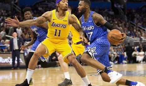 Forward Orlando Magic Jonathan Simmons (17) membawa bola dengan penjagaan forward Los Angeles Lakers, Michael Beasley (11) dalam lanjutan liga NBA, Ahad (18/11) pagi WIB