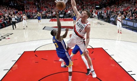 Forward Portland Trail Blazers, Meyers Leonard (kanan), melakukan halauan terhadap serangan forward Golden State Warriors, Draymond Green, dalam laga gim 4 final Wilayah Barat NBA di Portland, Ore, Senin (20/5).