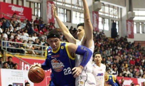 Forward Satria Muda Vinton Noland Surawi berusaha melewati forward Bandung Utama Andre Tiara dalam lanjutan NBL Indonesia Seri II Bandung, Ahad (14/12).