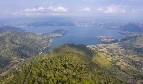 Foto aerial Danau Toba dari kawasan wisata menara pandang Tele di Turpuk Limbong, Harian, Kabupaten Samosir, Sumatera Utara, Ahad (21/2/2021). Menteri Koordinator Kemaritiman dan Investasi Luhut Binsar Pandjaitan mengungkapkan kejuaraan dunia balap perahu cepat F1 Powerboat (F1H2O) di Danau Toba, Sumatra Utara, merupakan sarana untuk lebih mempromosikan pariwisata Indonesia ke dunia internasional.