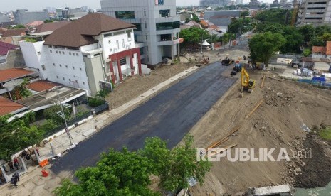 Foto aerial pekerja melakukan proses 'prime coat' pada urukan tanah sebelum diaspal di lokasi jalan ambles di Jalan Raya Gubeng, Surabaya, Jawa Timur, Rabu (26/12/2018). 