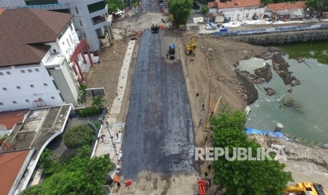 Foto aerial pekerja melakukan proses 'prime coat' pada urukan tanah sebelum diaspal di lokasi jalan ambles di Jalan Raya Gubeng, Surabaya, Jawa Timur, Rabu (26/12/2018). 