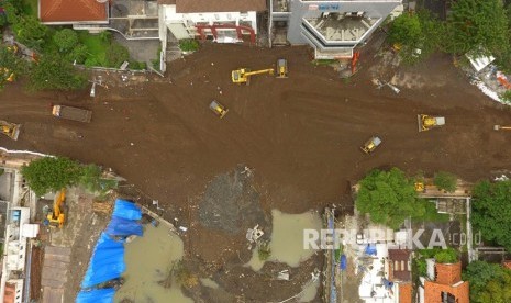 Foto aerial sejumlah alat berat meratakan urukan di lokasi jalan ambles di Jalan Raya Gubeng, Surabaya, Jawa Timur, Ahad (23/12/2018).