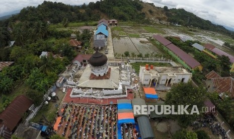 Foto aerial umat muslim menunaikan Shalat Jumat di Masjid Jamik Quba, Pidie Jaya, NAD, Jumat (9/12).