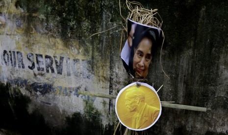 Foto Aung San Suu Kyi ditempatkan di dinding sebelum dibakar oleh aktivis organisasi ultra-kiri dalam aksi demonstrasi menentang penganiayaan Muslim Rohingya, di Kolkata, India, Senin (4/9).