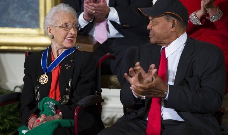 Foto tahun 2015 menunjukkan Willie Mays (kanan) memberi apresiasi ke matematikawan NASA Katherine Johnson yang baru mendapat penghargaan dari Presiden Obama. Jalanan di luar NASA kini diberi nama Hidden Figures Way, bentuk penghargaan wanita Afrika Amerika yang bekerja sebagai komputer manusia kala itu.