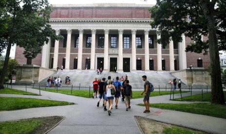  Foto tahun 2019 memperlihatkan mahasiswa berjalan di Kampus Harvard di Cambridge, Massachusetts, AS. Kebijakan Imigrasi AS yang melarang mahasiswa asing bertahan di negaranya bila hanya mengambil kelas daring dikecam banyak pihak. 