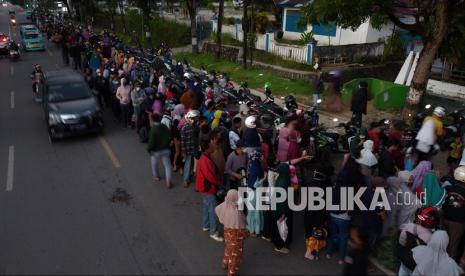 Foto udara antrean warga hingga di badan jalan untuk mendapatkan minyak goreng murah dalam kemasan di pasar murah di Kantor Dinas Perindustrian dan Perdagangan Provinsi Sulawesi Tenggara, Kendari, Sulawesi Tenggara, Kamis (17/3/2022). Untuk mendapatkan minyak goreng murah dalam kemasan warga rela antre sejak pukul 03.00 dini hari dengan syarat membawa foto copy kartu keluarga.