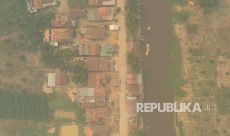 Foto udara kawasan permukiman penduduk yang diselimuti kabut asap di Arang-arang, Kumpeh Ulu, Muarojambi, Jambi, Kamis (15/8/2019). 