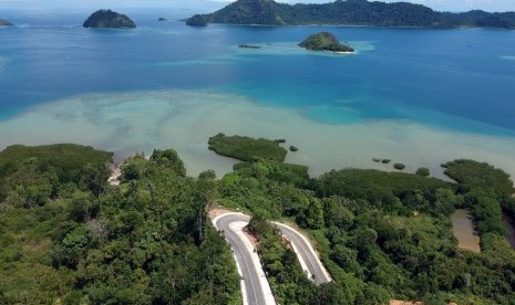 Foto udara kendaraan melintas di jalan akses wisata ke Nagari Mandeh, Pesisir Selatan, Sumatera Barat, Selasa (3/7).