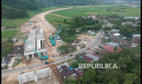 Foto udara proyek pembangunan jembatan layang Tol Padang - Pekanbaru di Jalan Raya Padang - Bukittinggi, Pasar Usang, Kabupaten Padangpariaman, Sumatera Barat, Kamis (8/7/2021). Data PT Hutama Karya (Persero), progres pembangunan tol itu telah mencapai 41,218 persen dan difokuskan pada penyelesaian jembatan layang dengan panjang 150 meter di posisi Sta 6+050 - Sta 6+200.