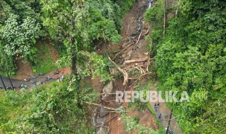 Foto udara sejumlah anggota TNI Kodim 0710 Pekalongan beserta relawan membersihkan material longsor di Jembatan Jangkar, Lebakbarang, Kabupaten Pekalongan, Jawa Tengah, Rabu (26/1/2022). Longsor yang terjadi akibat intensitas hujan deras dan angin kencang pada Selasa (25/1) itu juga menyebabkan pohon-pohon berdiameter sekitar 50-100 centimeter tumbang dan menutup total akses jalan utama warga Kecamatan Lebakbarang dan Karanganyar.