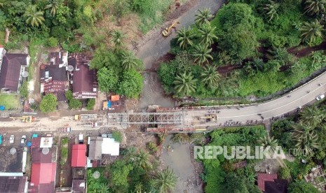 Foto udara sejumlah pekerja memasang panel jembatan sementara di Batang Kalu, Jalur Padang - Pekanbaru, Kayutanam, Padangpariaman, Sumatera Barat, Kamis (13/12/2018). 