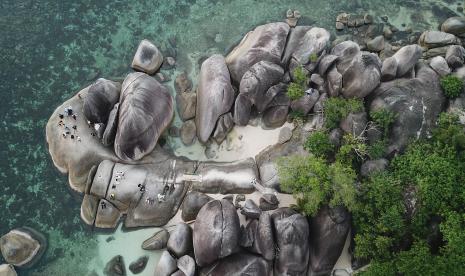 Foto udara wisatawan berlibur di Pantai Tanjung Tinggi, Belitung, Kepulauan Bangka Belitung, Sabtu (21/5/2022). Pemerintah Provinsi Kepulauan Bangka Belitung memfokuskan peningkatan ekonomi masyarakat berbasis kelautan dan perikanan. Ini sebagai bentuk transformasi perekonomian dari pertambangan bijih timah di daerah itu.