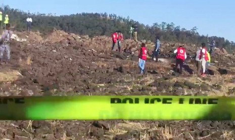 Foto yang diambil dari video menunjukkan petugas mencari korban diantara puing-puing jatuhnya pesawat Ethiopian Airlines di daerah Hejere sekitar 50 km dari selatan Addis Ababa Kenya, Ahad (10/3).