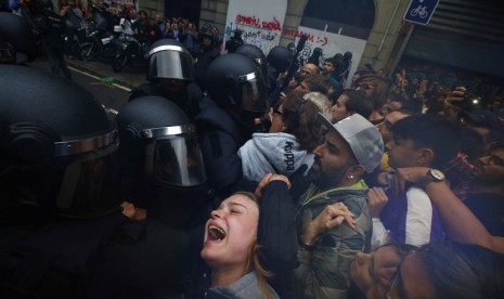  Foto yang diambil pada Minggu (1/10) memperlihatkan seorang gadis berteriak histeris kepada petugas Polisi Spanyol yang berusaha membubarkan para pendukung pro referendum kemerdekaan katalunya di luar gedung sekolah Ramon Llull di Barcelona.