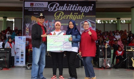 Founder Shafira Corporation (Shafco) Feny Mustafa (kanan) memberikan grandprize berupa paket umrah dalam peringatan Hari Jadi Kota Bukittinggi ke-232 di Bukittinggi, Sabtu (24/12).   